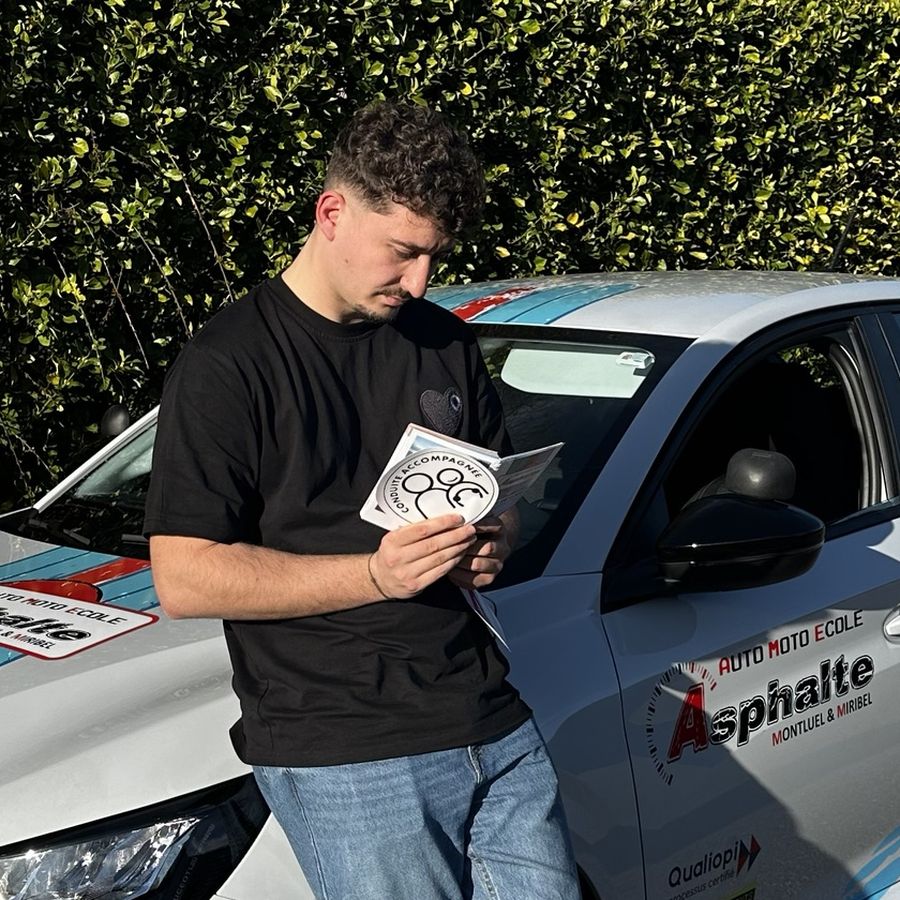 Corentin, co-gérant et enseignant, devant une voiture-école Asphalte