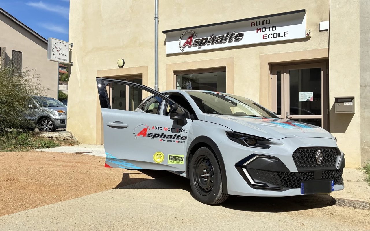 L'agence Asphalte de Montluel et une voiture-école devant la façade
