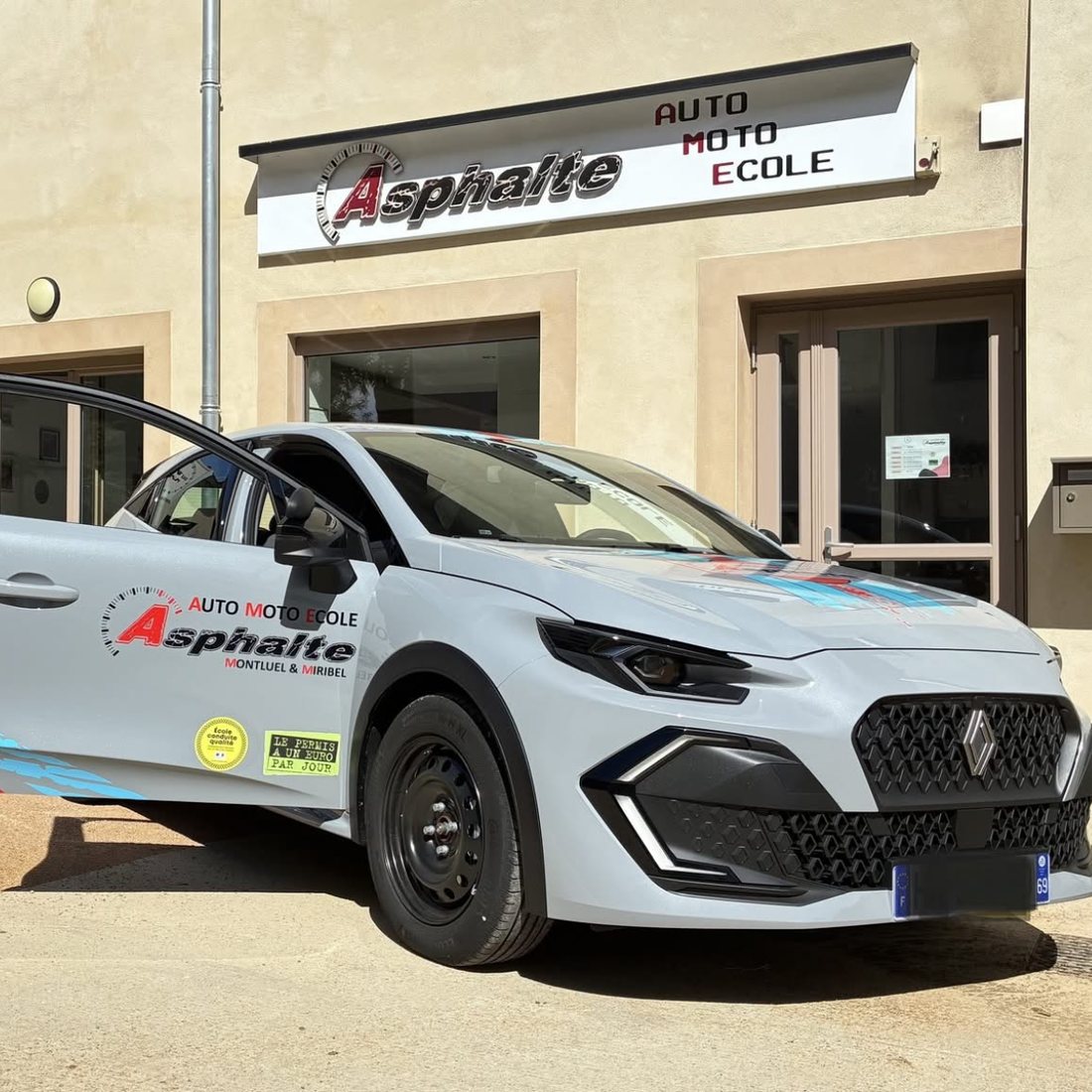 Une voiture-école Asphalte devant l'agence de Montluel